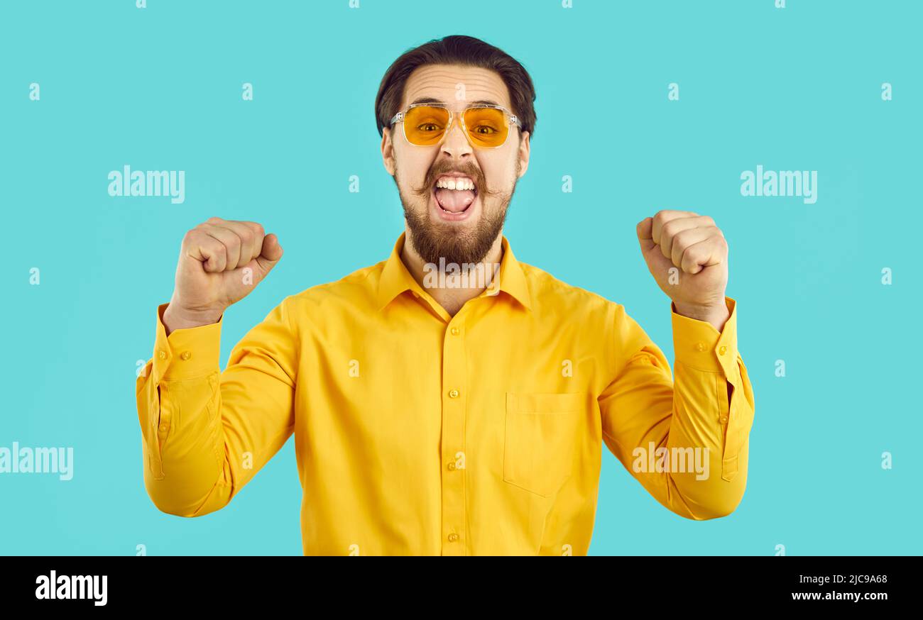 Happy stylish witzig funky verrückt Hipster Kerl schreiend vor Freude auf hellblauem Hintergrund. Stockfoto