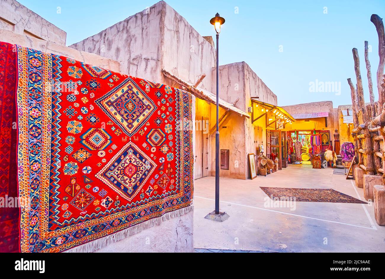 Der Straßenmarkt im Viertel Al Seef mit bunten Teppichen, Souvenirs, Kleidungsstücken und Accessoires, Dubai, VAE Stockfoto