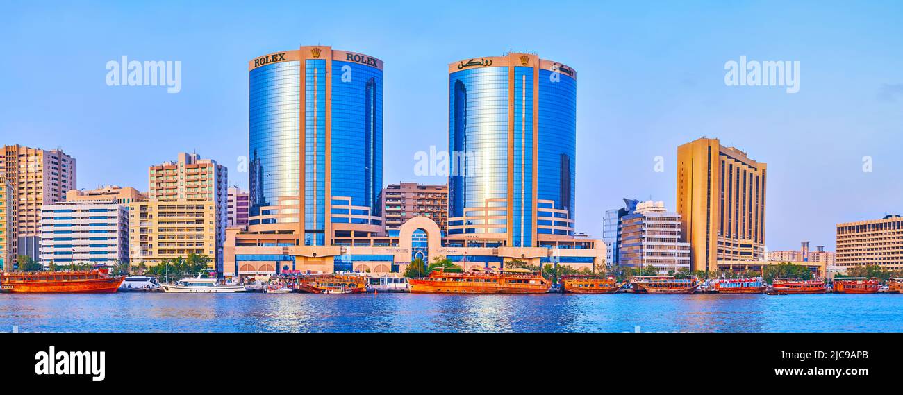 DUBAI, VAE - 1. MÄRZ 2020: Panorama des modernen Viertels mit den Deira Twin Towers und einer Reihe von hölzernen Dhau-Booten am Ufer des Dubai Creek, am 1. März in Stockfoto