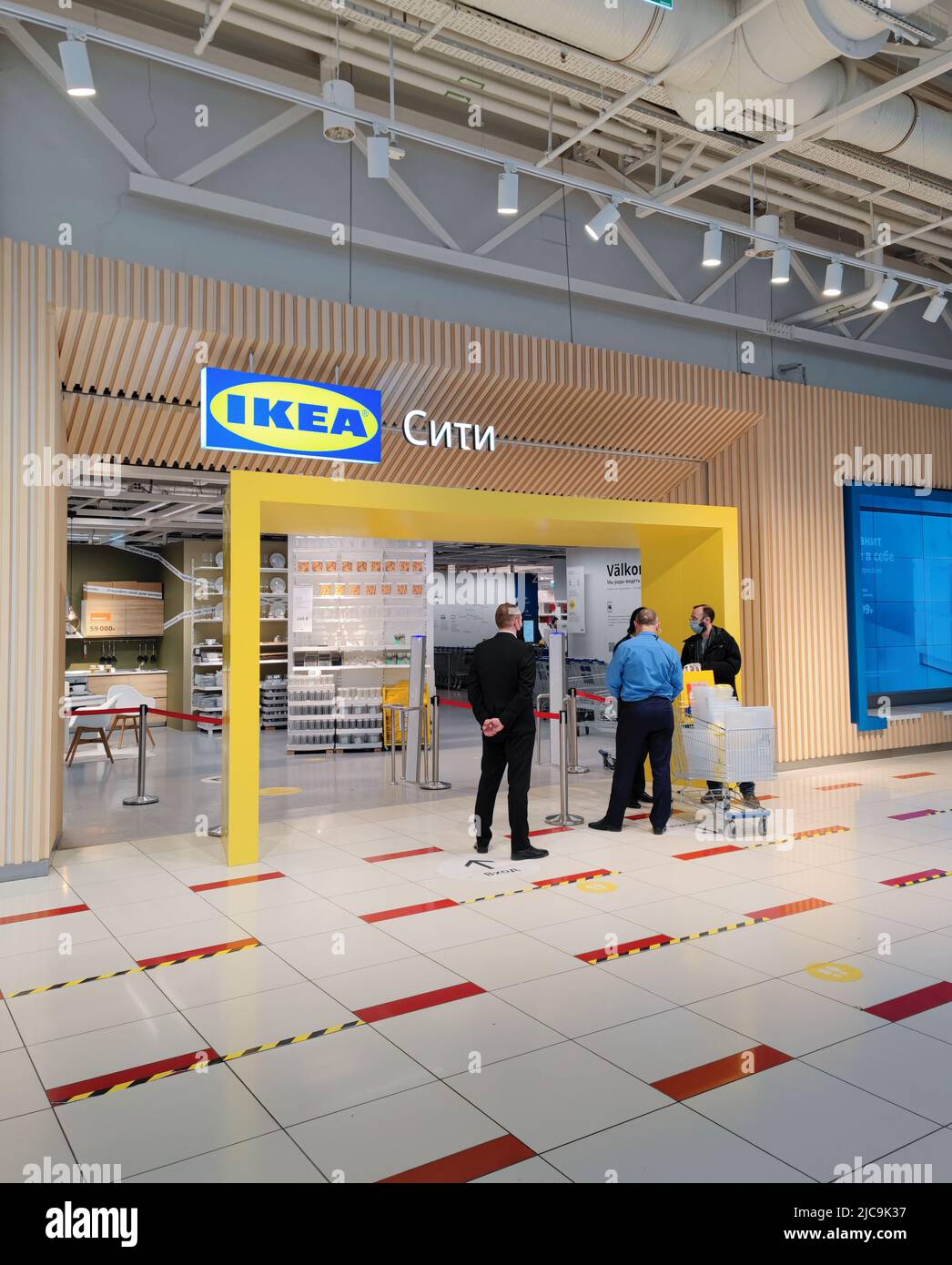 Moskau, Russland, März 2022: Eintritt in den IKEA-Store. Wachen unterhalten sich mit einem Mann in Schwarz, der Einkäufe tätigt. Im Inneren kann man Regale mit Waren sehen. Stockfoto