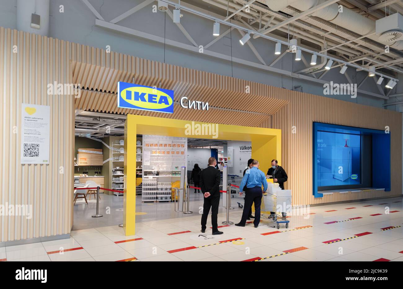 Moskau, Russland, März 2022: Eintritt in den IKEA-Store. Wachen unterhalten sich mit einem Mann in Schwarz, der Einkäufe tätigt. Im Inneren kann man Regale mit Waren sehen. Stockfoto