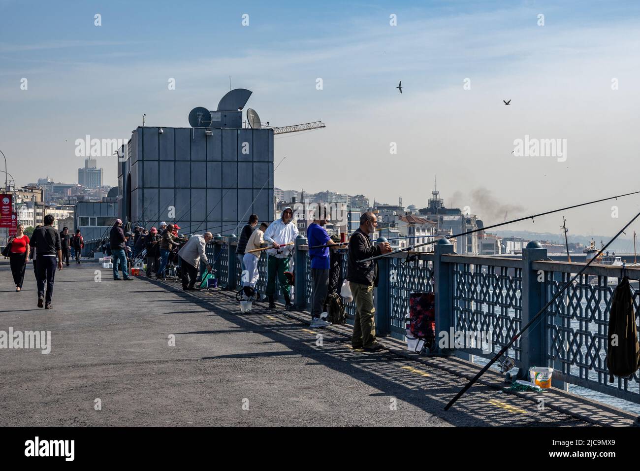 Menschen, die von der Galata-Brücke über die Wasserstraße des Goldenen Horns fischen. Istanbul, Türkiye. Stockfoto
