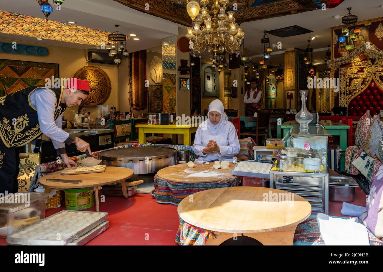 Eine Frau, die in einem Geschäft traditionelles türkisches Brot herstellt. Istanbul, Türkiye. Stockfoto