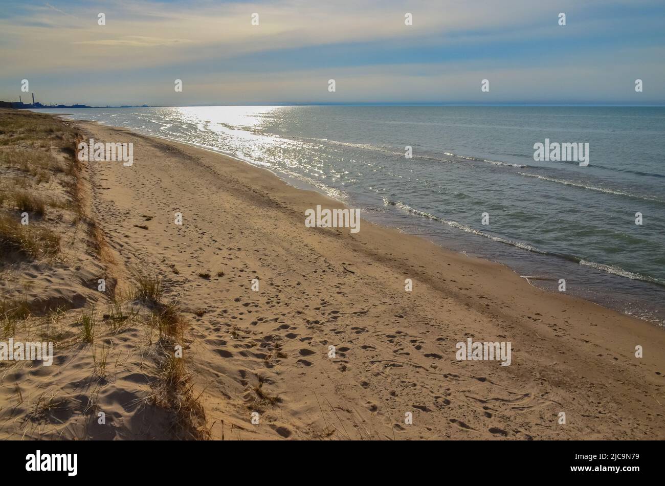 Sanddünen am Ufer eines großen Sees, Spiegelung der Sonne im Wasser. Indiana Dunes National Lakeshore, USA Stockfoto