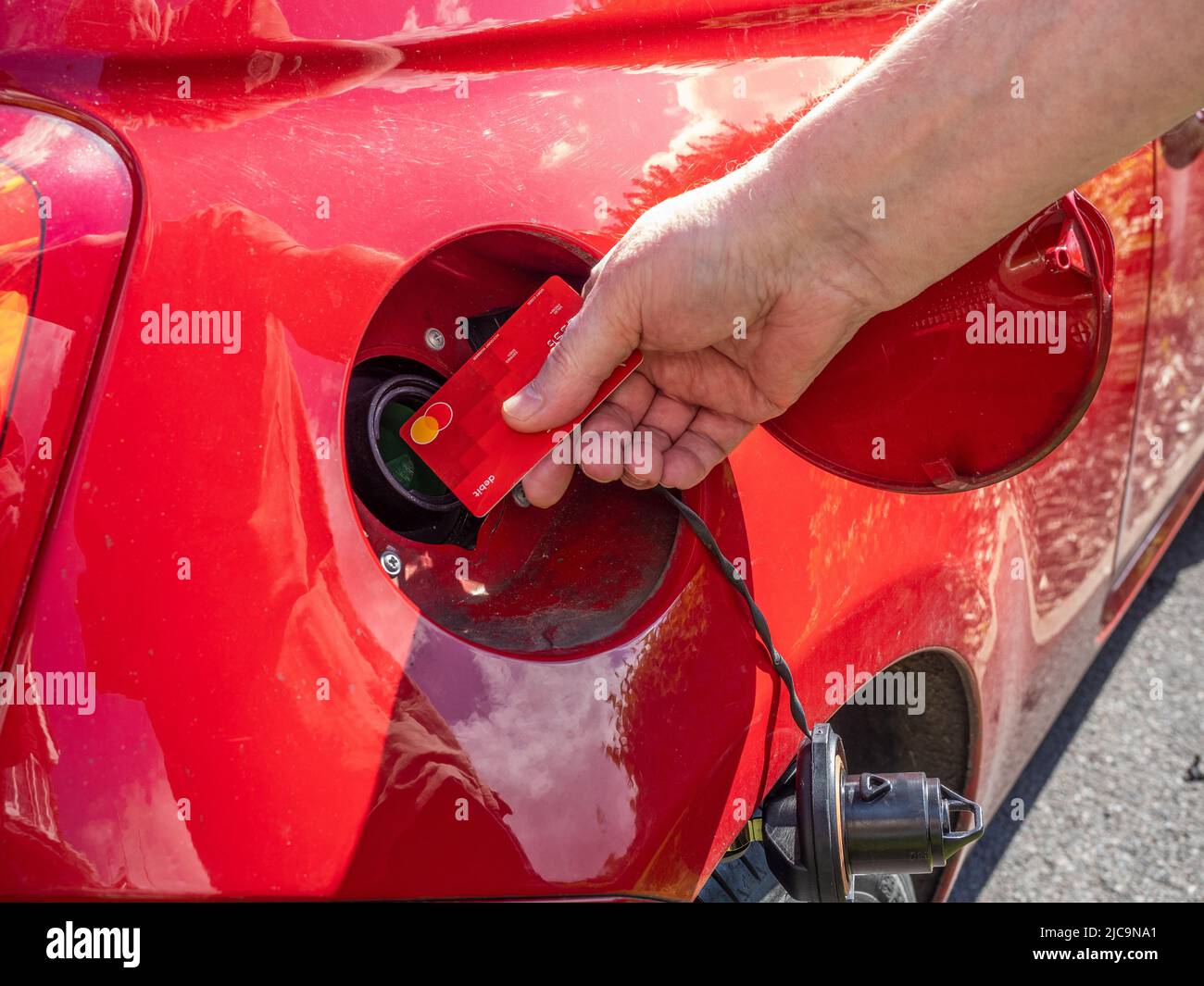 Bankkartendarstellung des Preisaufstiegs bei Diesel-Benzin Krise, in der 2022 das Auto an einer Tankstelle aufgefüllt wurde Stockfoto