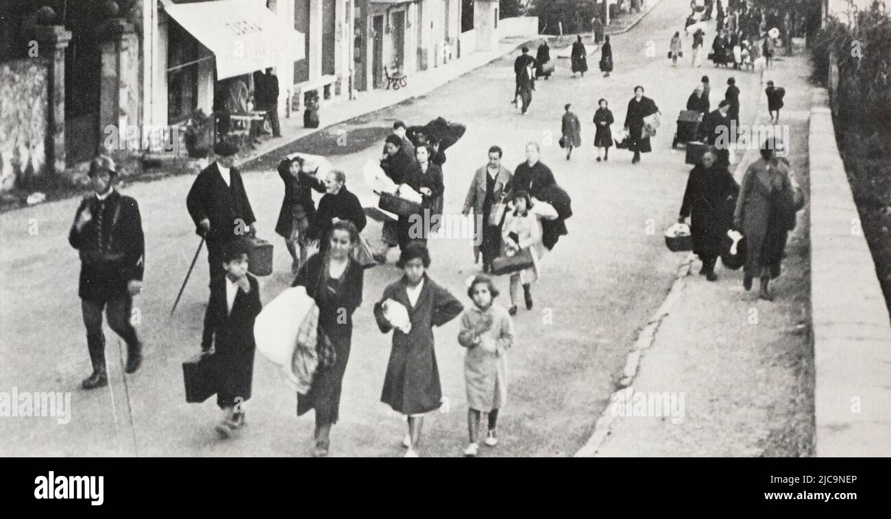 Eng translation : ' in Hendaye: Die endlose Parade von Evakuierten aus Irun (Frauen, Kinder, alte Menschen), die, unmittelbar nach dem Überqueren der Grenzbrücke über die Bidassoa, von französischen Gendarmen begrüßt werden, die sie zu provisorischen Unterkünften bringen. DER SPANIEN-KRIEG ' - Original in Französisch : ' à Hendaye : l'inminable défilé des évacués d’Irun (femmes, enfants, vieillards) qui, aussitôt après avoir franchi le pont frontière sur la Bidassoa, sont accueillis par des gendarmes français qui les conduisent vers des abris de Fortune. LA GUERRE D’ESPAGNE ' - Auszug aus ' L'Illustration, Journal Universel ' Stockfoto