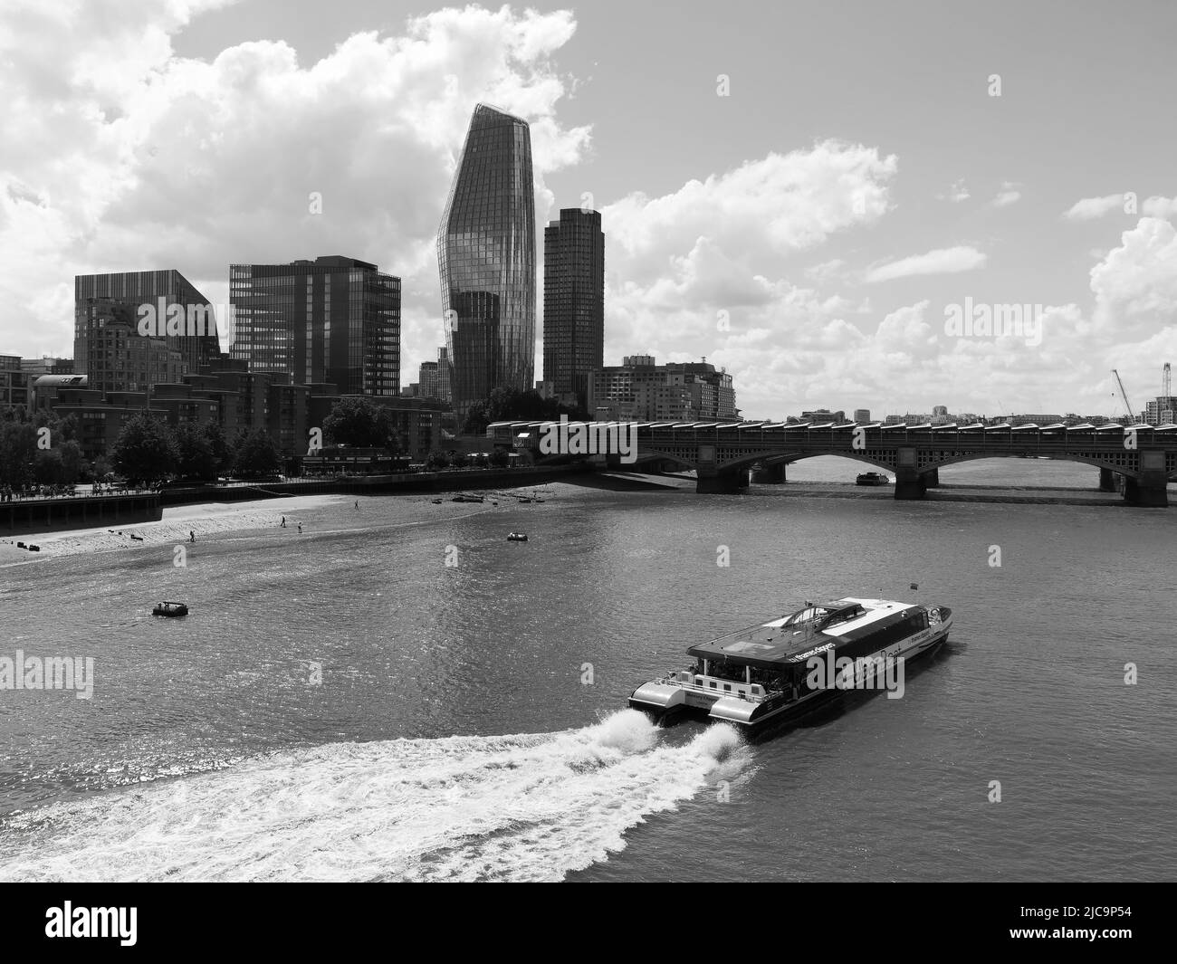 London, Großraum London, England, Juni 08 2022: Monochrom. Uber Boot auf der Themse mit Blackfriars Bridge dahinter. Stockfoto