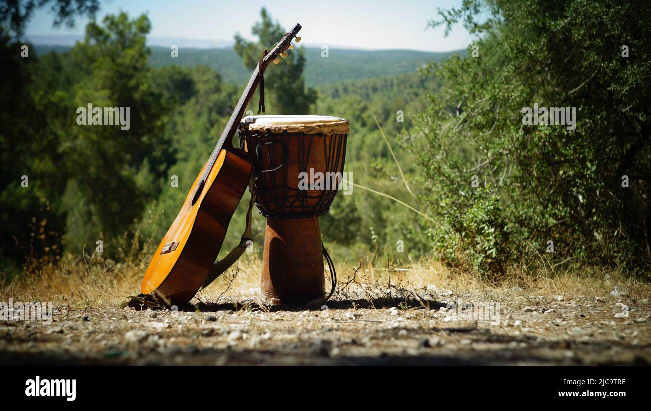 Gitarre und afrikanische Djembe-Trommel in der Natur Stockfoto