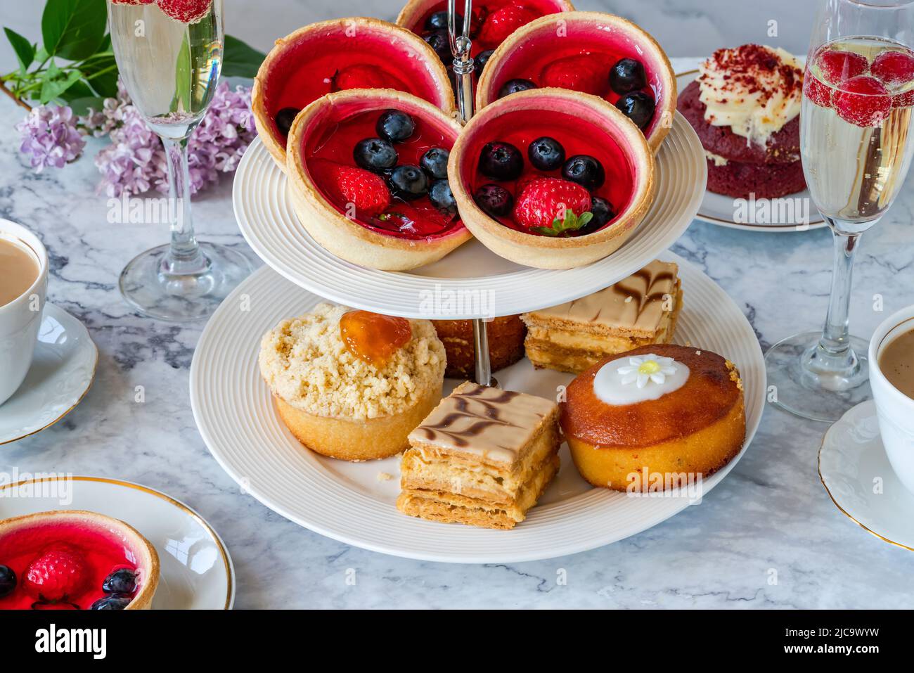 Auswahl an Gourmet-Kuchen mit Kaffee und Sekt auf einem Tisch Stockfoto