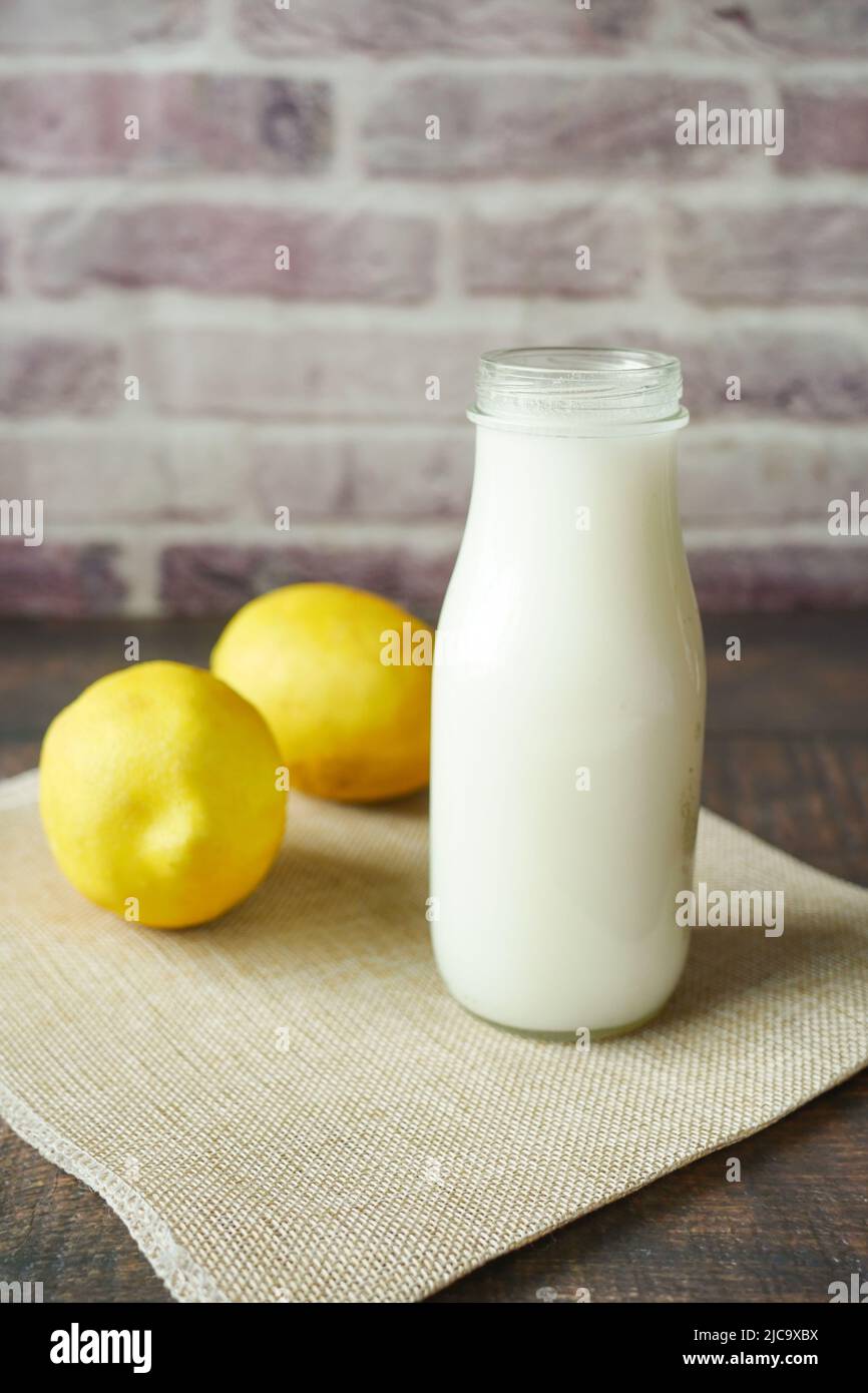 Milchglas und gelbe Zitrone auf dem Tisch Stockfoto