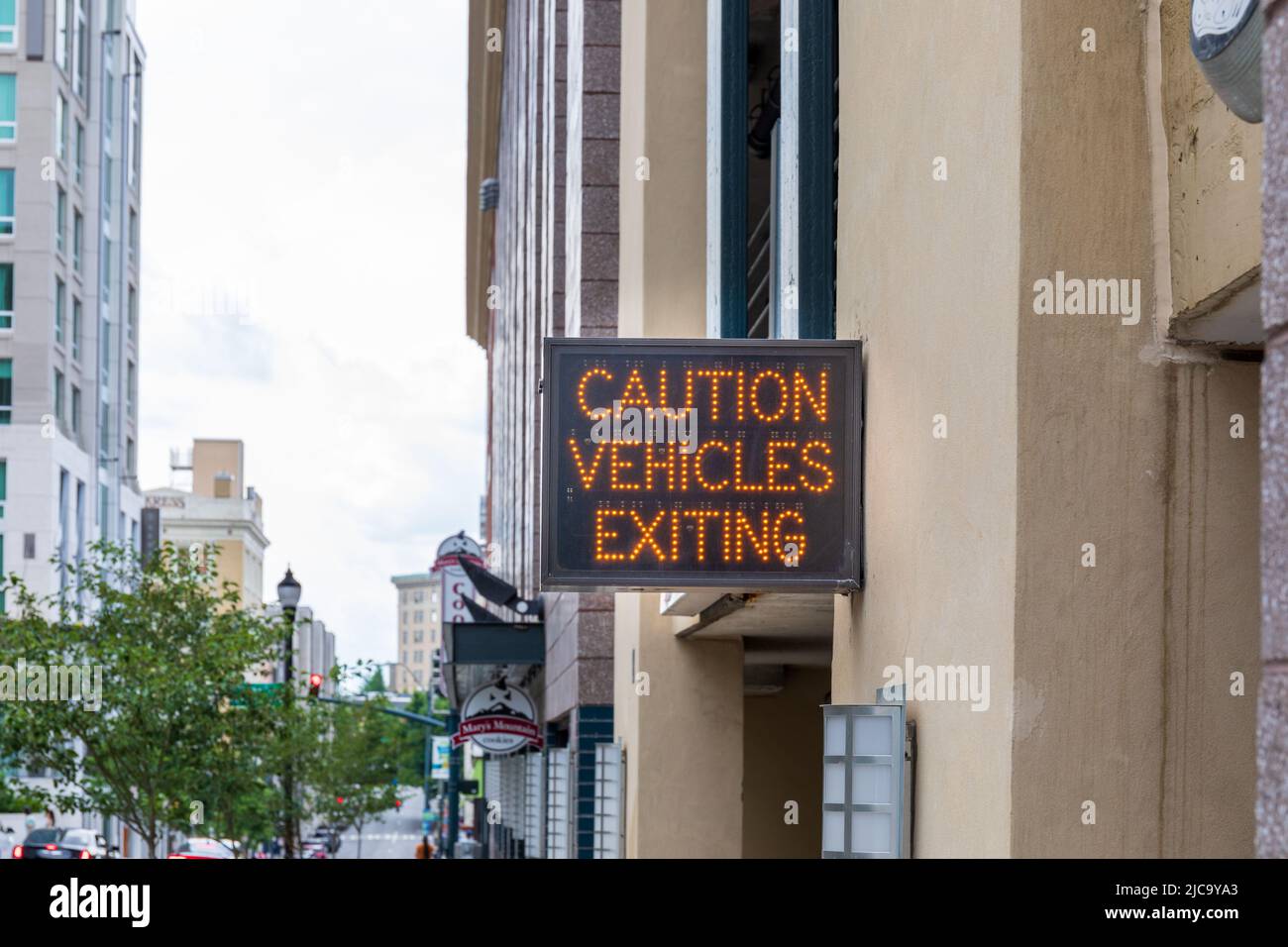 ASHEVILLE, NC, USA-5 JUNE 2022: Digital-Schild am Parkgarage-Ausgang: Vorsicht Fahrzeuge verlassen. Stockfoto