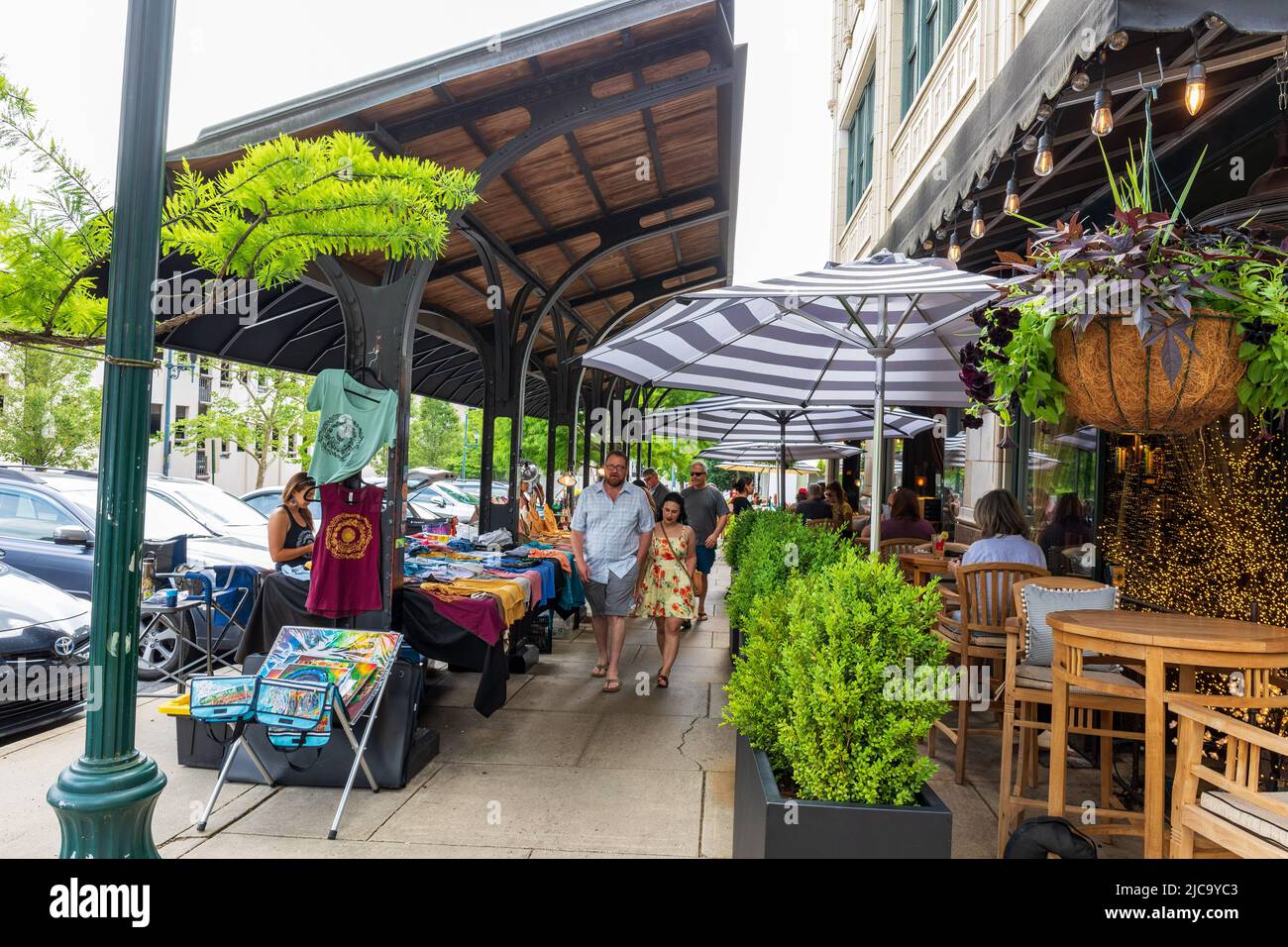 ASHEVILLE, NC, USA-5 JUNE 2022: Händler auf dem Bürgersteig in der Grove Arcade. Mehrere Menschen einkaufen und vorbeigehen. Stockfoto