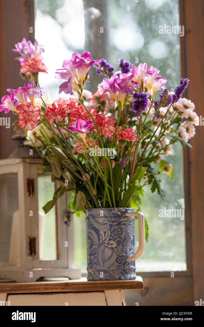 Blauer Krug mit bunten Sommerblumen Stockfoto