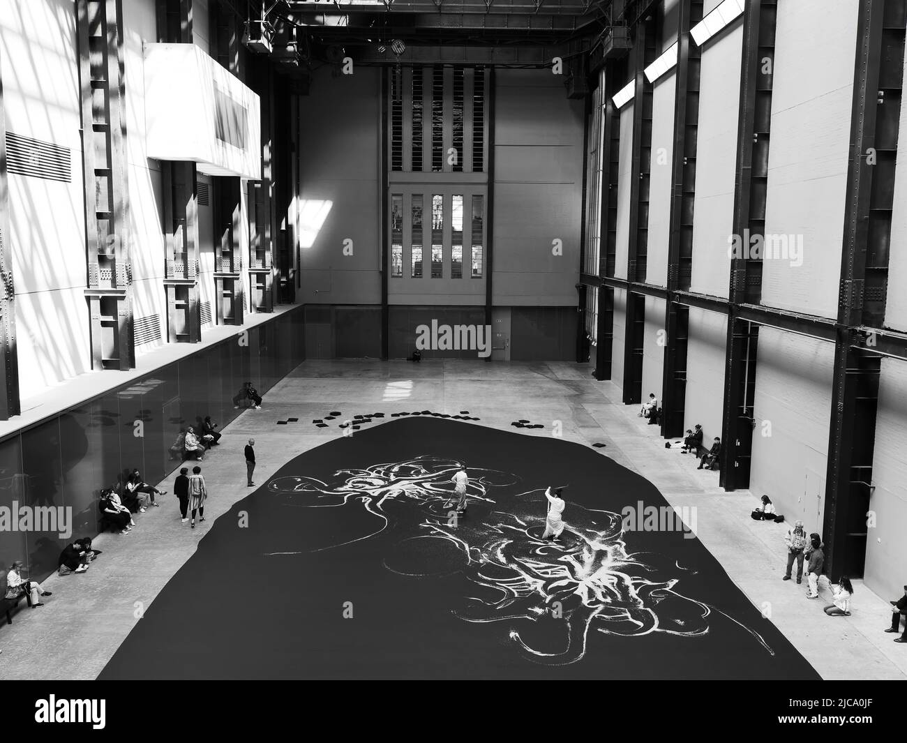 London, Großraum London, England, Juni 08 2022: Monochrom. Interieur der Tate Modern mit einer Live-Ausstellung, die von Besuchern beobachtet wird. Stockfoto