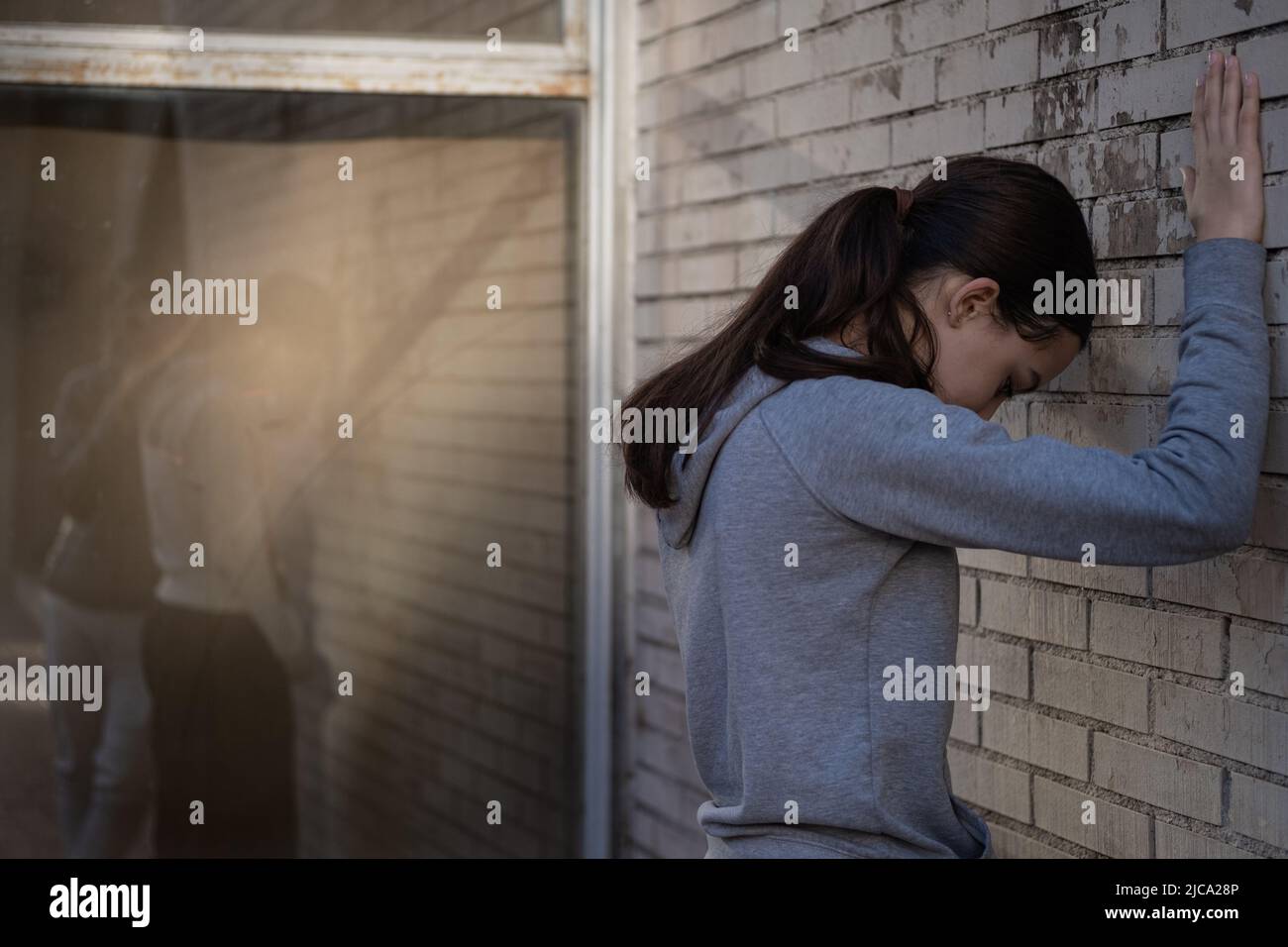 Unglückliches junges Paar. Auf Glas reflektiert steht ein Junge neben einem depressiven Mädchen. Stockfoto