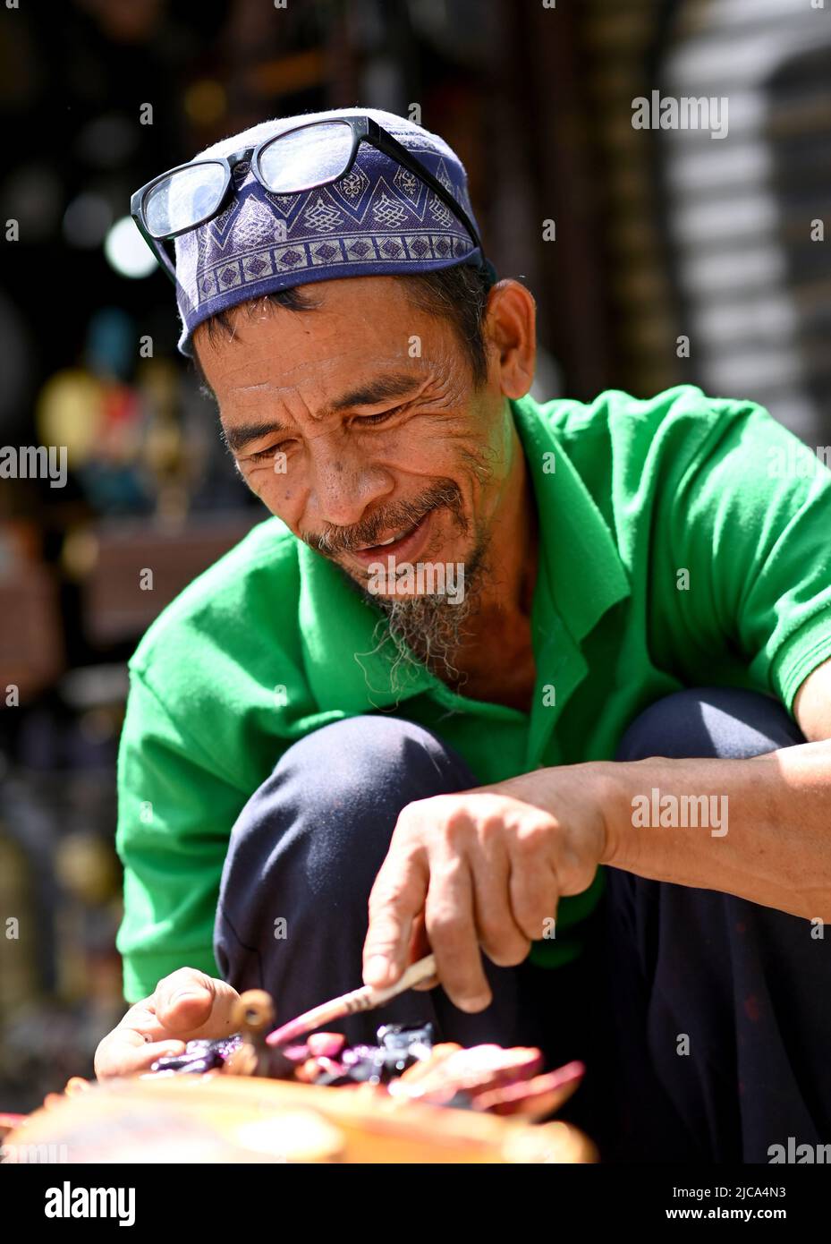 Jakarta, Indonesien. Mann, der handgeschnitzte hölzerne Souvenirs im Straßenhandelsgeschäft jakarta Souvenirladen macht. BILD VON SAM BAGNALL Stockfoto