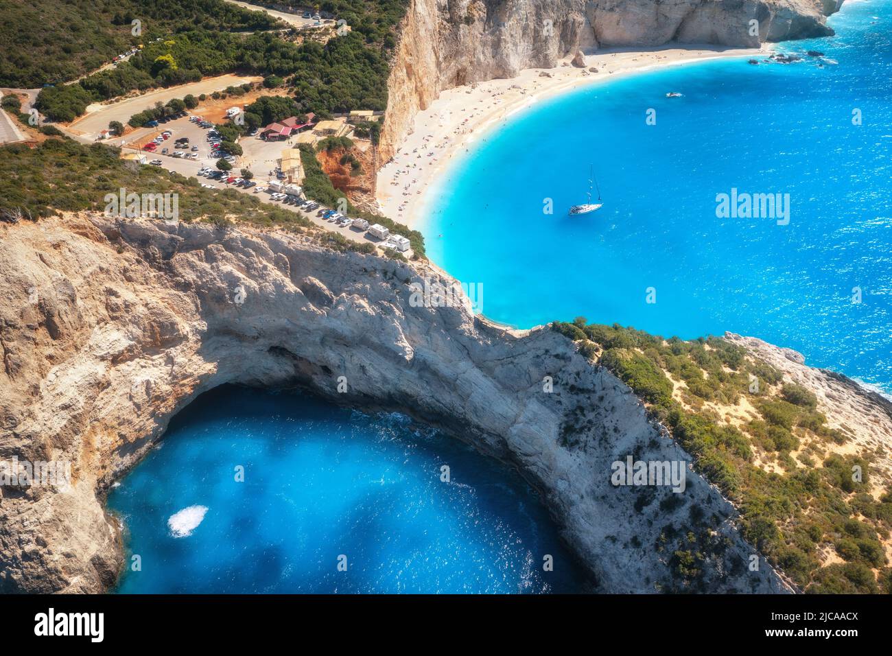 Luftaufnahme von blauem Meer, Bergen, weißem Sandstrand bei Sonnenaufgang Stockfoto