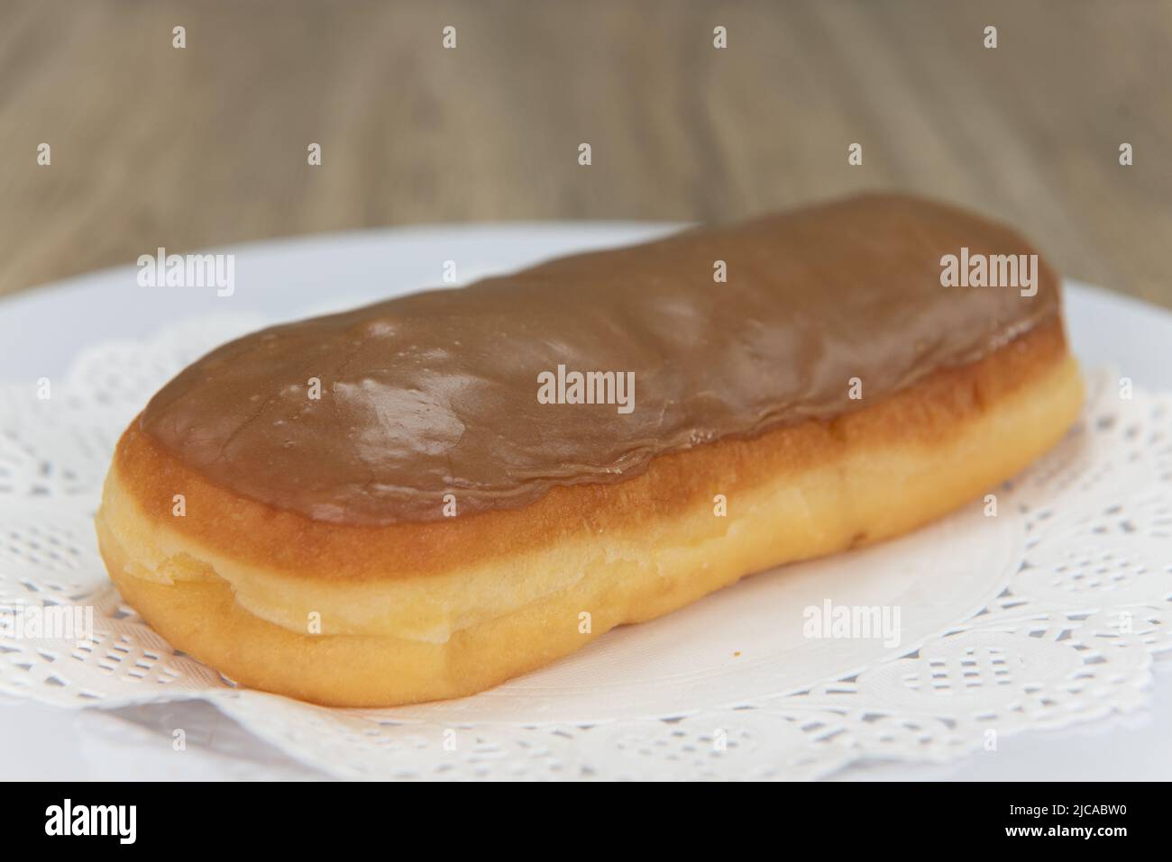 Verführerisch frisch aus dem Ofen Ahornholz-Riegel-Donut aus der Bäckerei auf einem Teller serviert. Stockfoto