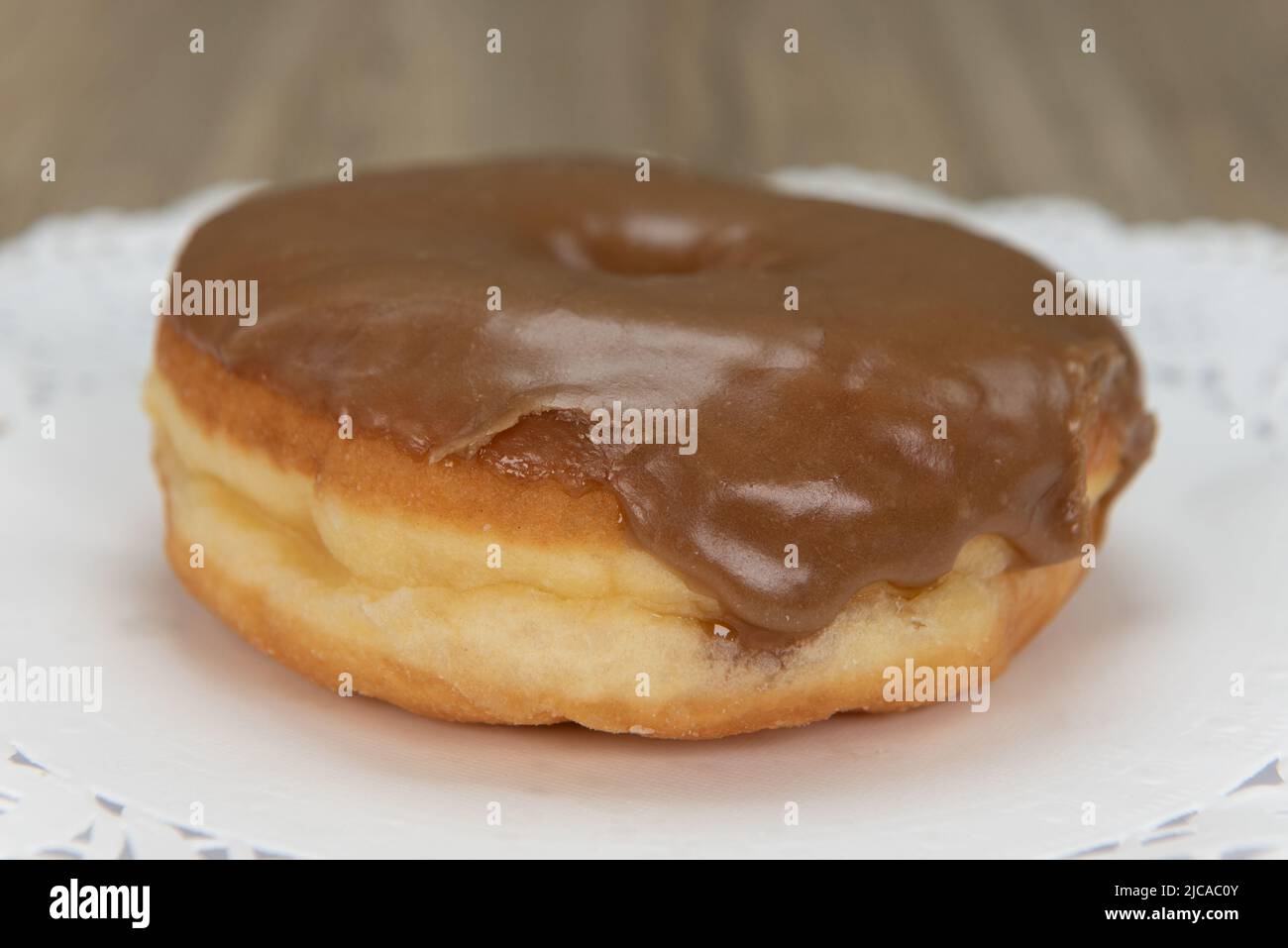 Verführerisch frisch aus dem Ofen Ahorndonut aus der Bäckerei auf einem Teller serviert. Stockfoto