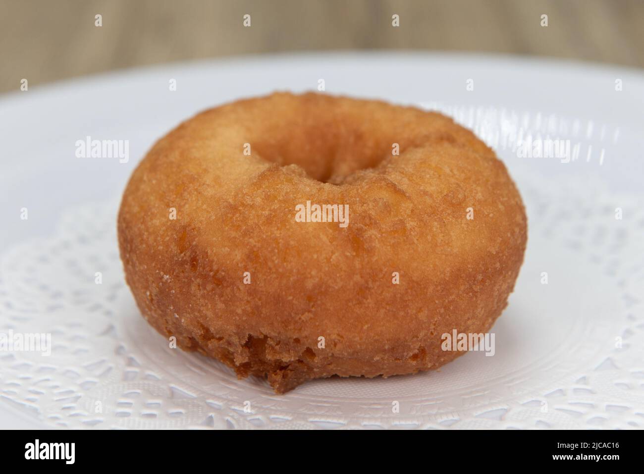 Verführerisch frisch aus dem Ofen schlichter Donut aus der Bäckerei auf einem Teller serviert. Stockfoto