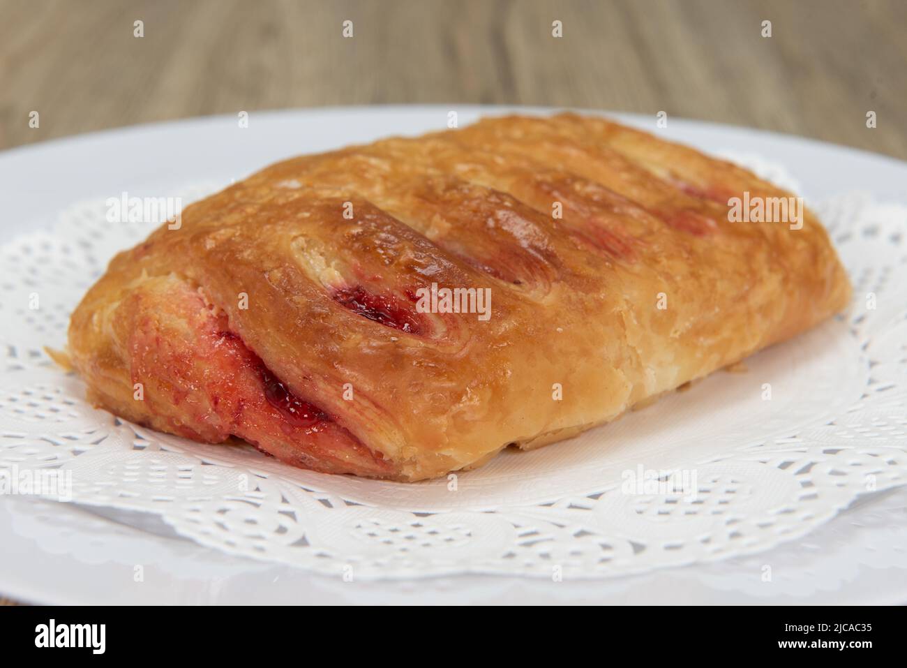 Verführerisch frisch aus dem Ofen Schokoladencroissant aus der Bäckerei auf einem Teller serviert. Stockfoto