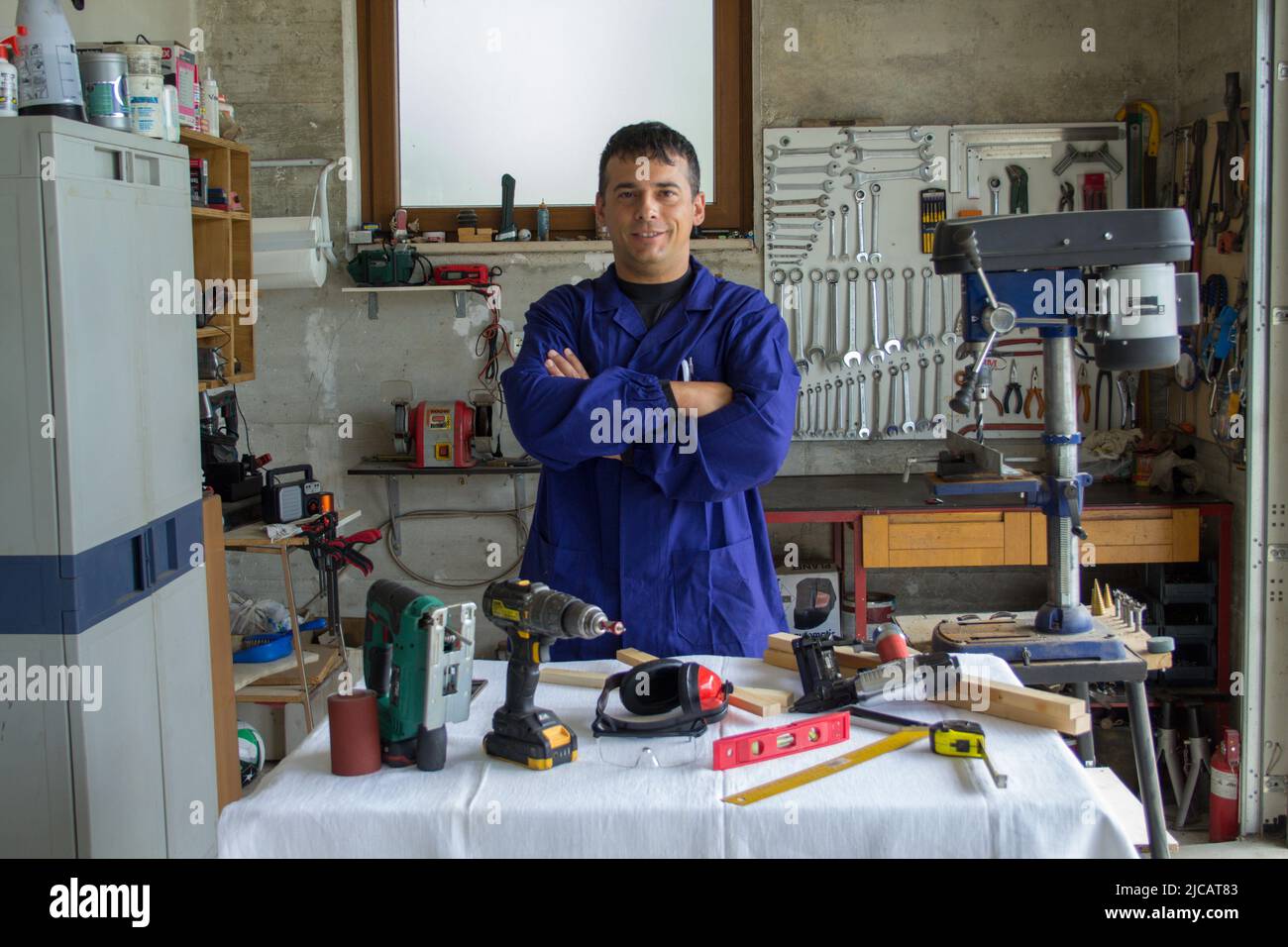 Bild eines Handwerkers in seiner Werkstatt mit einem Tisch vor Arbeitsgeräten. DIY-Arbeitsbeispiel und Verweis auf ich kann es beheben Stockfoto