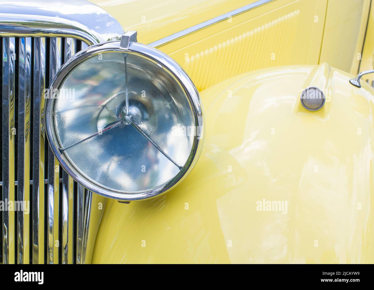 Hintergrund mit Scheinwerfer eines gelben nicht-modernen Autos, horizontales Format Stockfoto