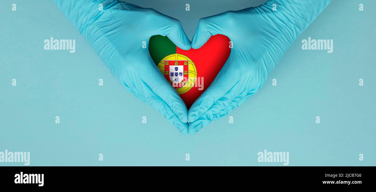 Ärzte Hände tragen blaue OP-Handschuhe, die ein Symbol mit der portugiesischen Flagge bilden Stockfoto