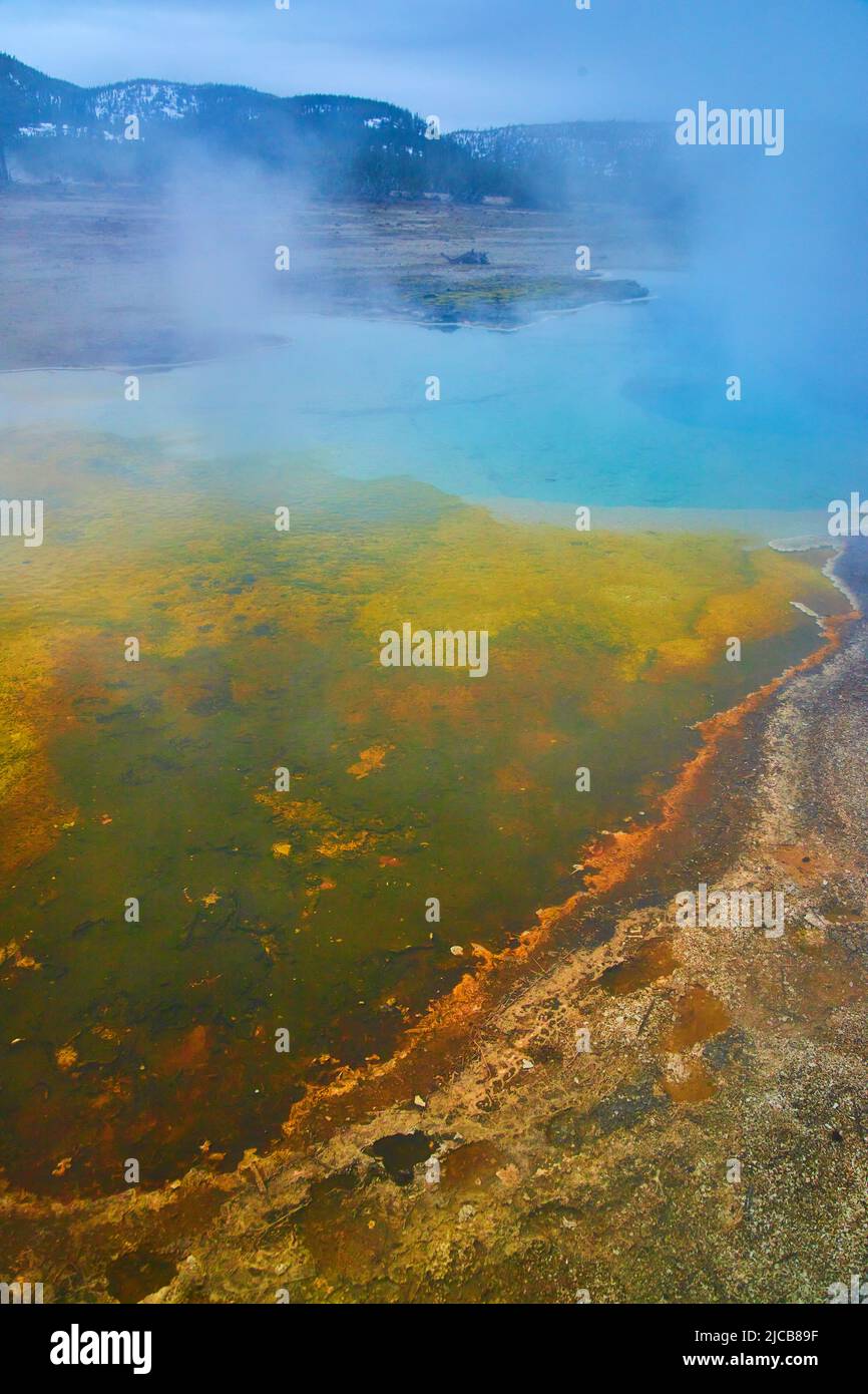 Geheimnisvolle Yellowstone Pools mit blauem und gelbem Wasser und Schwefeldampf Stockfoto