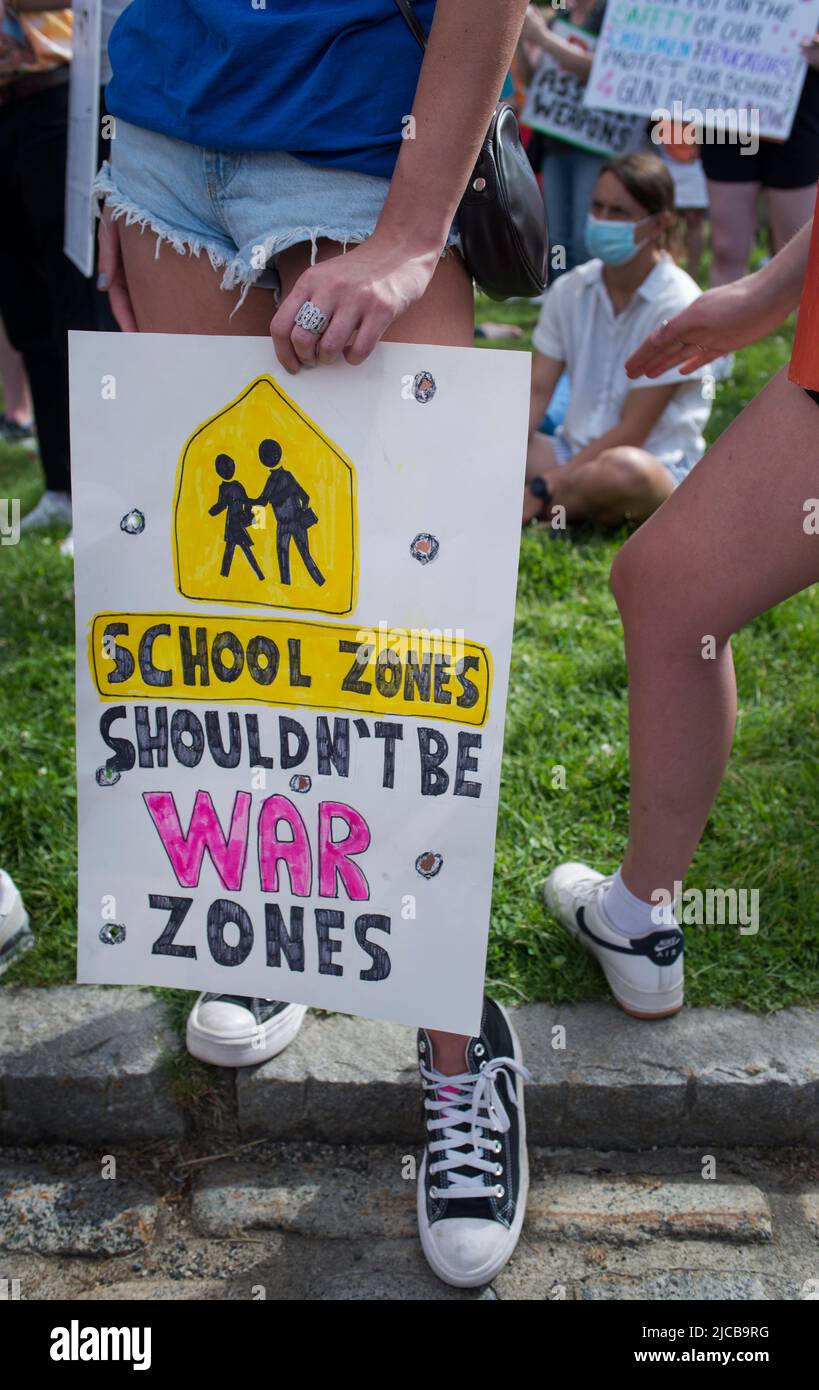 March for Our Lives 2022, Boston, MA, USA: Tausende versammelten sich am Ufer von Boston, als über 450 Demonstrationen gegen Waffengewalt in den USA stattfanden. Das Foto zeigt eine junge Frau, die Schuhe von Converse trägt und ein Schild mit eingeschnittenen Einschusslöchern in der Hand hält. Kredit: Chuck Nacke / Alamy Live Nachrichten Stockfoto