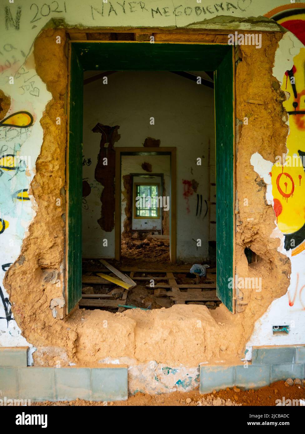 Verlassene Haus mit den Fenstern und Türen abgenutzt durch Feuchtigkeit, ein paar Stücke Holz als Bodenbelag Stockfoto