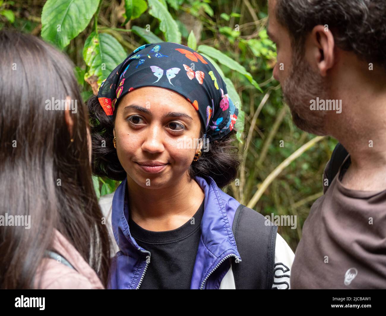 La Estrella, Antioquia, Kolumbien - Februar 13 2022: Braune Frau mit Schmetterlingskopftuch gehört ihren Freunden im Wald zu Stockfoto