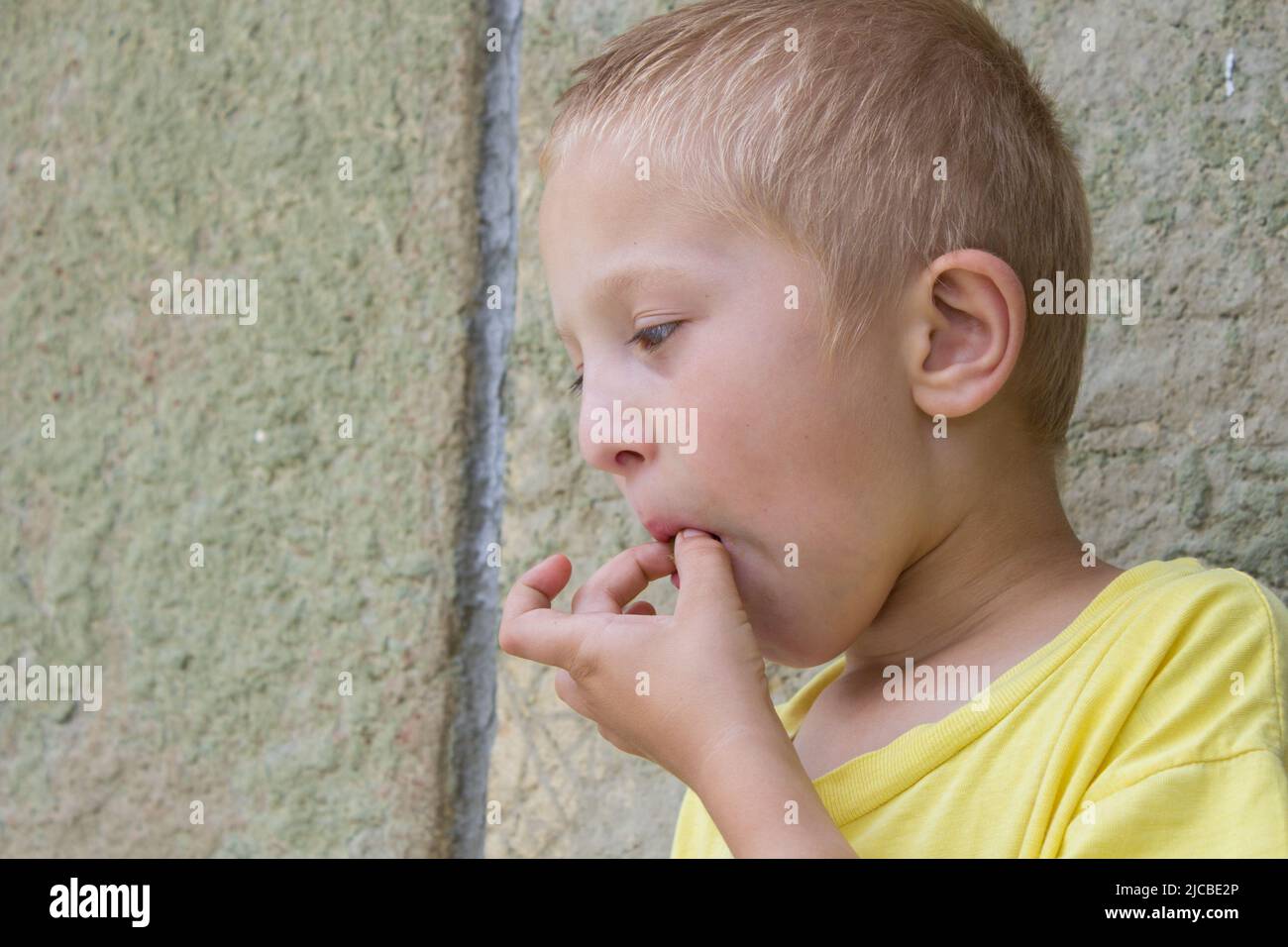 Junge zieht aus seinem Mund Aprikose Gruben Hände Stockfoto
