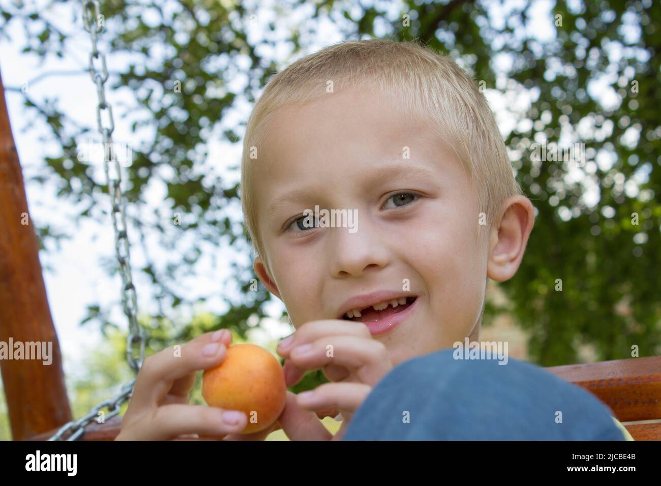 Porträt eines zahnlosen Jungen, der auf einer Bank sitzt Stockfoto