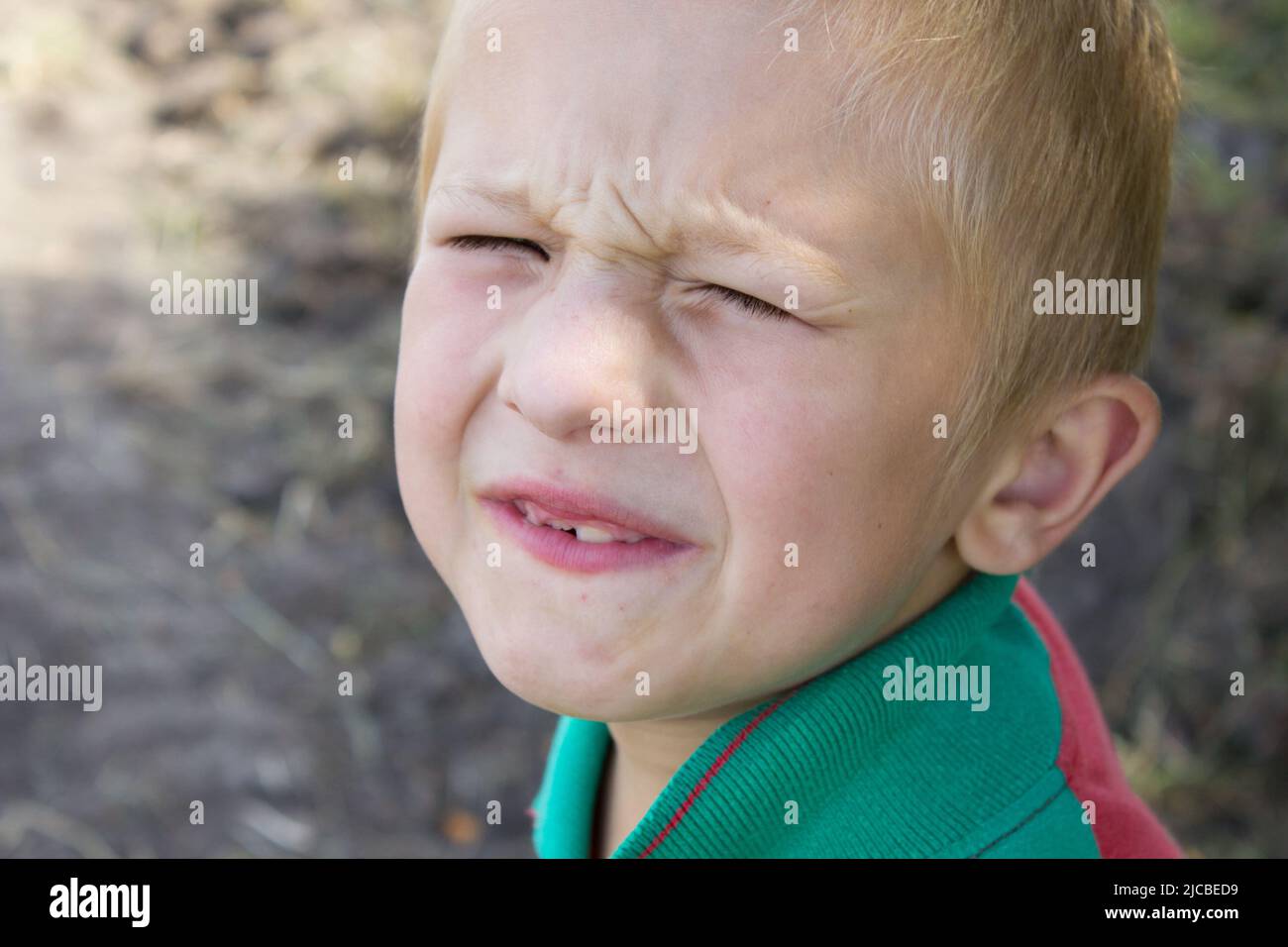 Porträtjunge hat seine Augen vor der Sonne verdreht Stockfoto