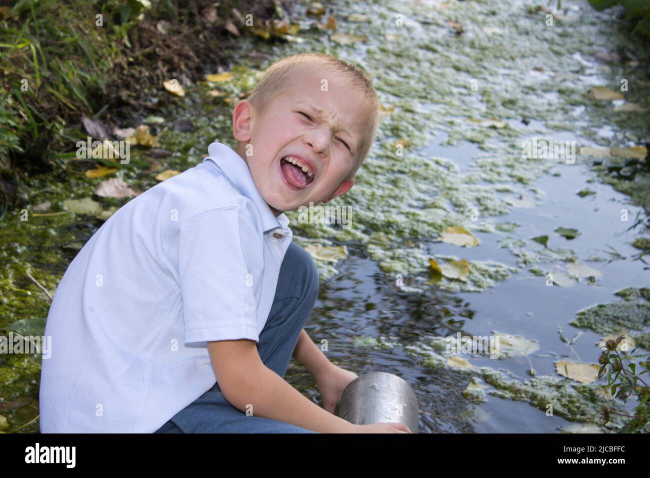 Junge zeigt Emotionen, die die Zunge in der Natur voranbringen Stockfoto