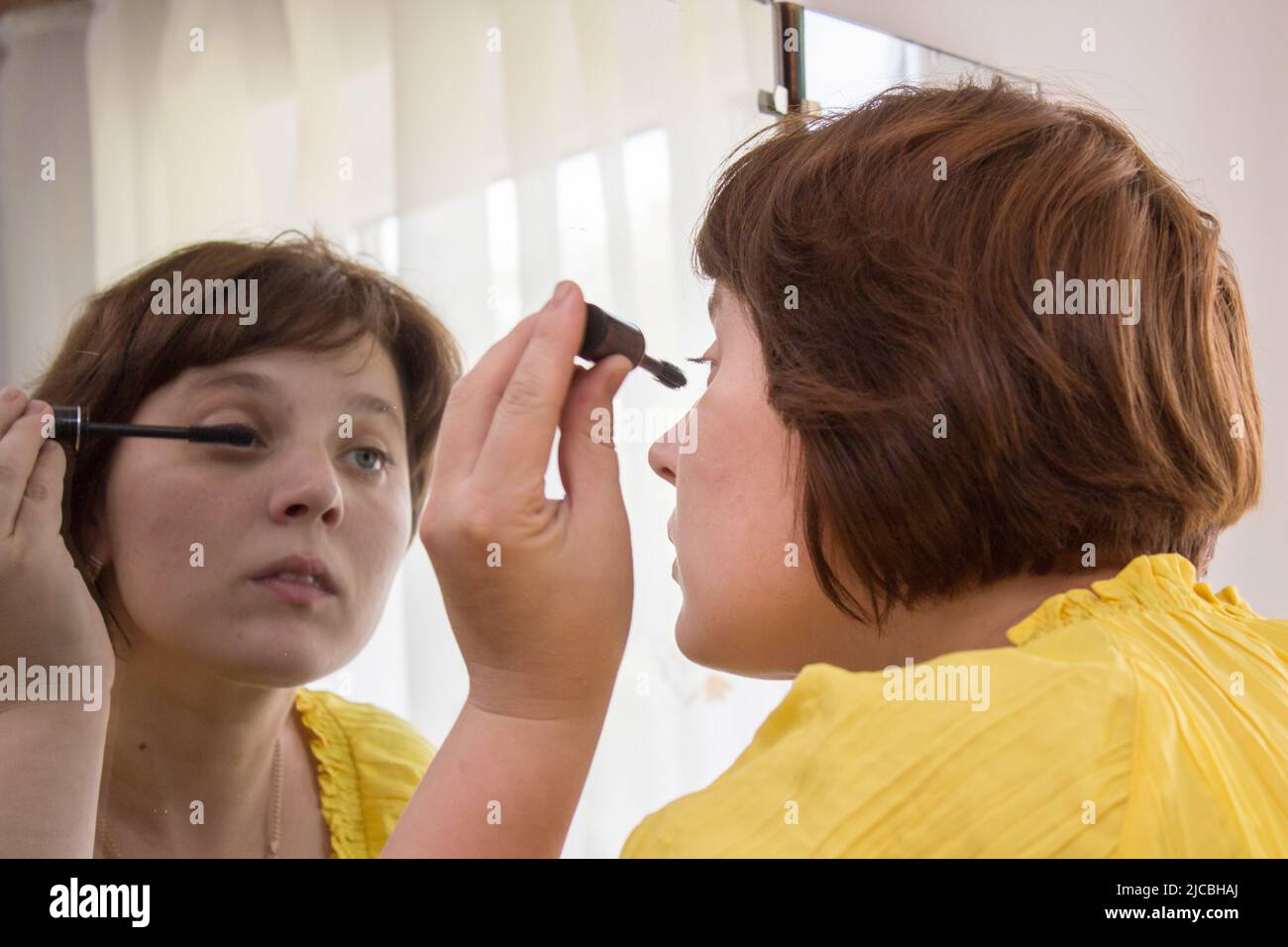 Frau in Kosmetikspiegel Stockfoto