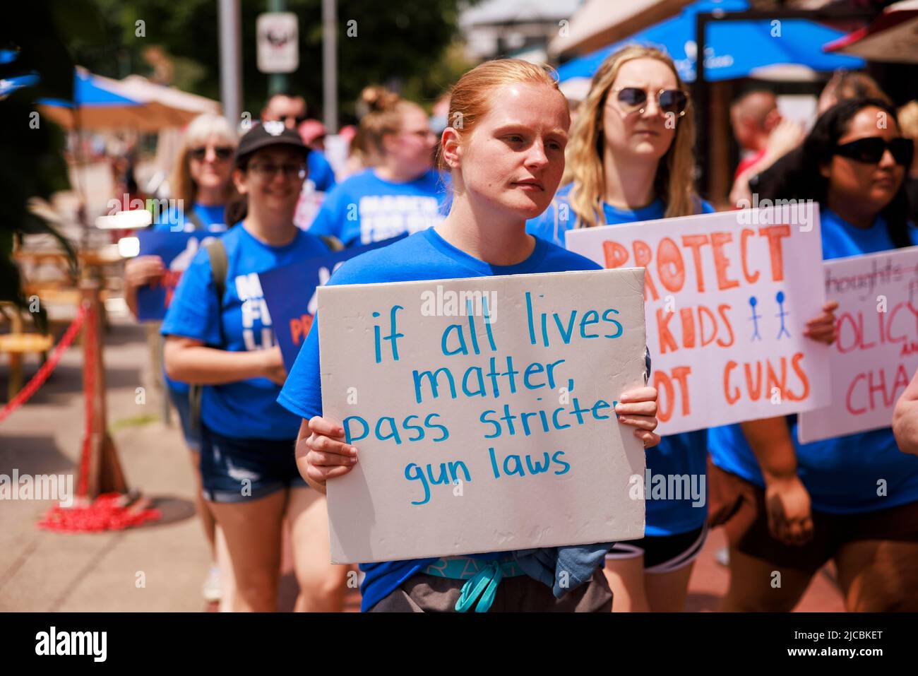 Bloomington, Usa. 11.. Juni 2022. Ein Marscher hält ein Plakat mit der Aufschrift „Wenn alle Leben eine Angelegenheit mit strengeren Waffengesetzen sind“, während Befürworter der Waffenkontrolle an einer „Marsch um unser Leben“-Kundgebung teilnehmen und in der Innenstadt von Bloomington marschieren. Ähnliche Proteste wurden in Städten in den Vereinigten Staaten nach mehreren Massenerschießungen organisiert. Kredit: SOPA Images Limited/Alamy Live Nachrichten Stockfoto