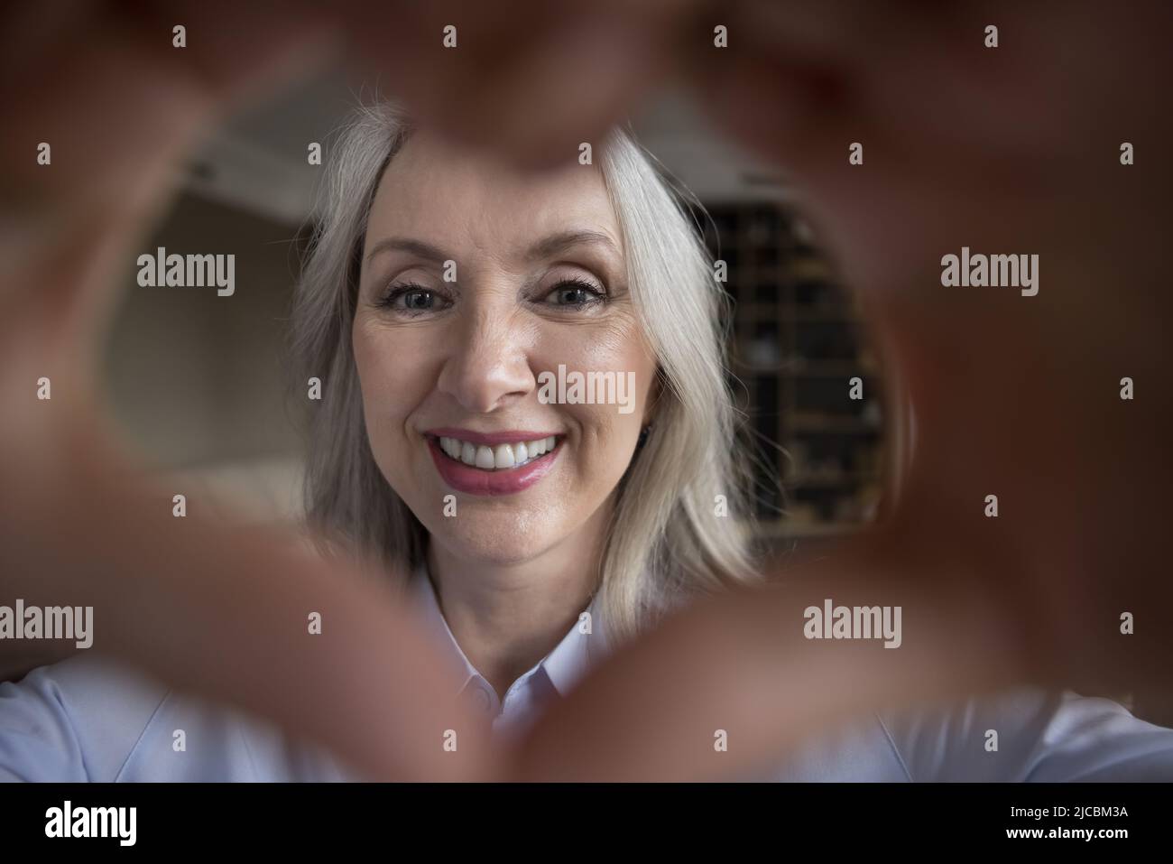 Nahaufnahme Gesicht der älteren Frau verbinden Finger zeigen Liebe Symbol Stockfoto