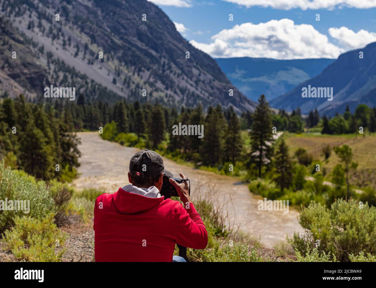 Ein Fotograf, der mit einer Digitalkamera in einem Gebirge fotografiert. Reise- und Active Lifestyle-Konzept. Kreative professionelle Fotografie. Phot Stockfoto