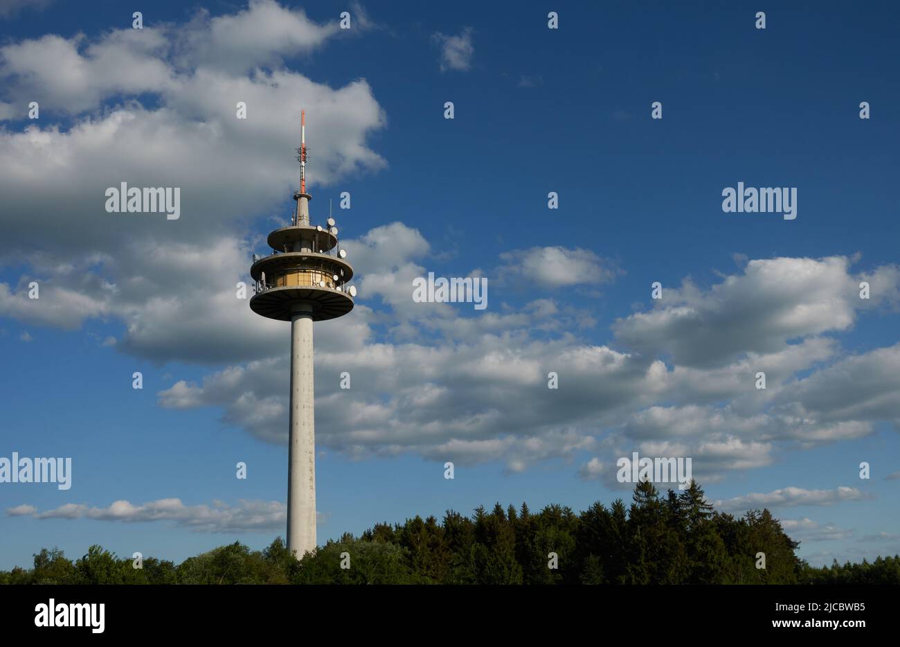 Große Wetterstation in Stötten, graue Wolken und blauer Himmel im Hintergrund, Wald mit vielen Bäumen im Vordergrund, der Turm befindet sich in der linken Hälfte Stockfoto