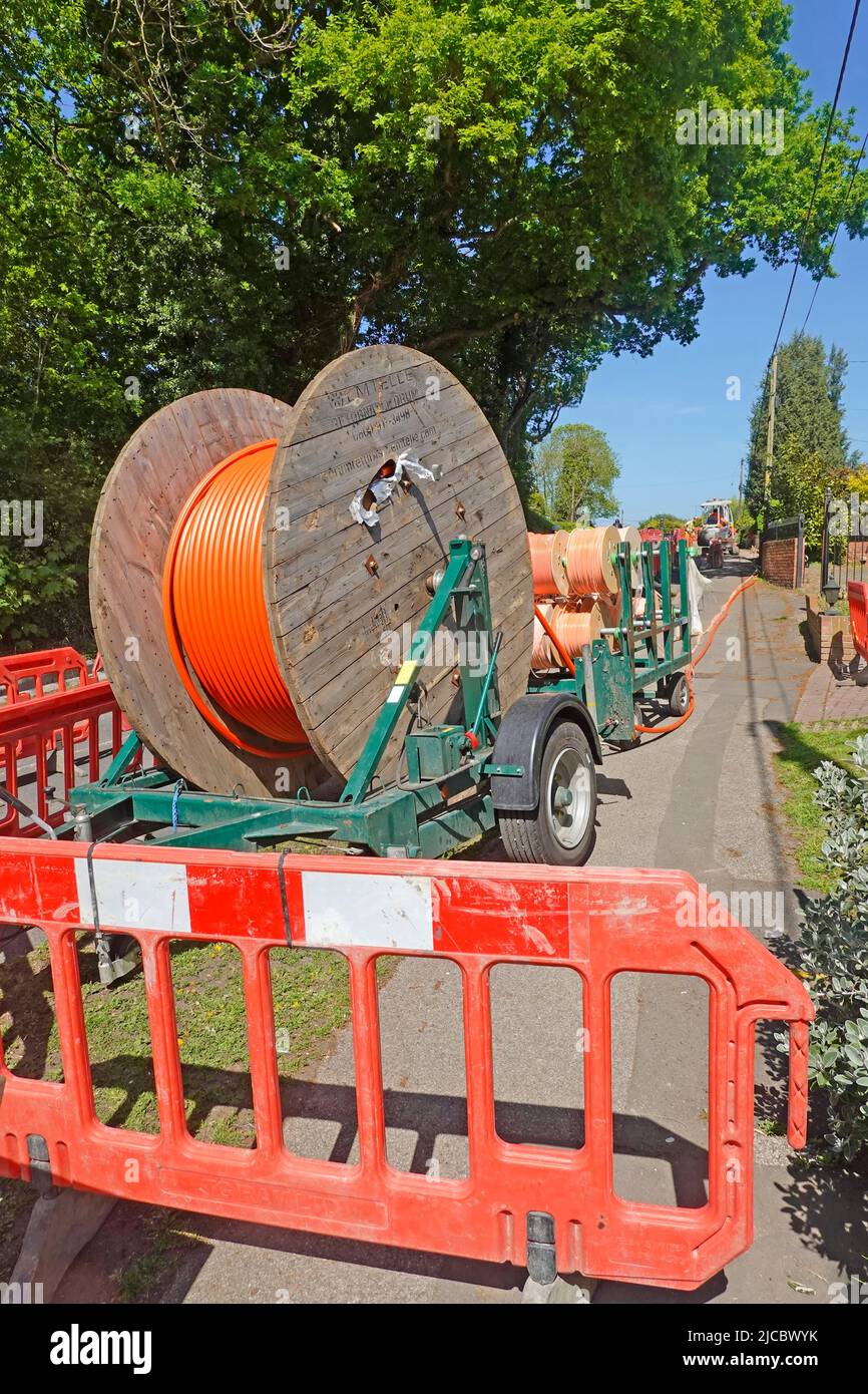 Superschnelles Breitbandinfrastrukturprojekt mit Glasfasertechnik in ländlichen Essex-Dorfkabeln auf Trommeln für die Verlegung in neuen flachen Straßengräben England Großbritannien Stockfoto