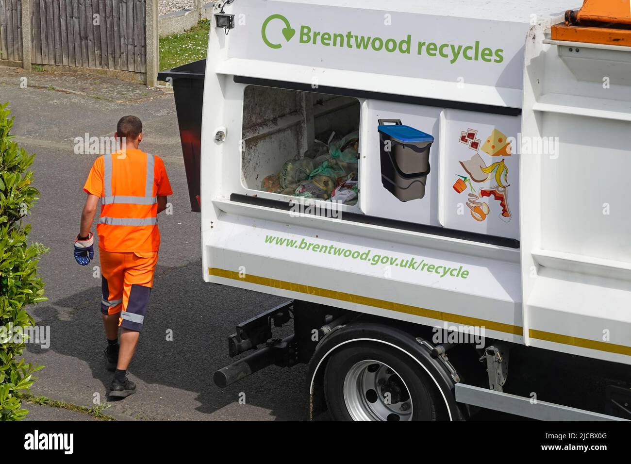 LKW-Fahrer für Lebensmittelrecycling mit gut sichtbarer Arbeitskleidung und offener Schiebetür Brentwood Council Waste Caddy Collection LKW Essex England UK Stockfoto