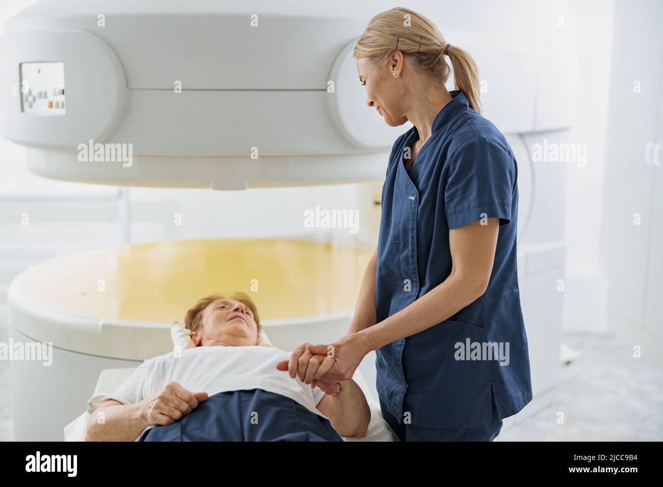 Der Radiologe kontrolliert die MRT- oder CT- oder PET-Scans bei einer weiblichen Patientin, die sich einem Eingriff unterziehen muss Stockfoto