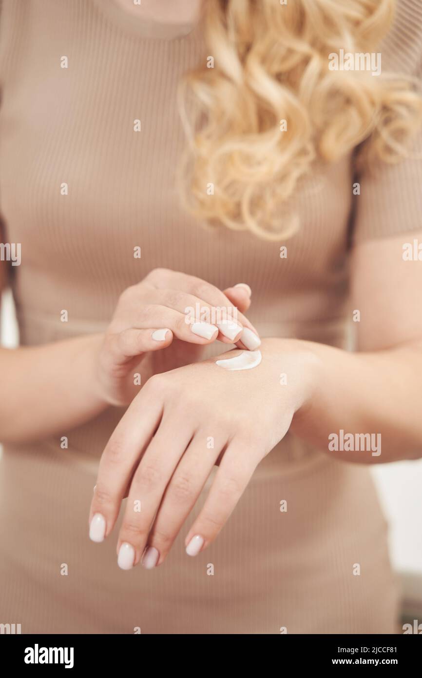 Cropped Foto von charmanten eleganten Frau Arme mit Creme Stockfoto