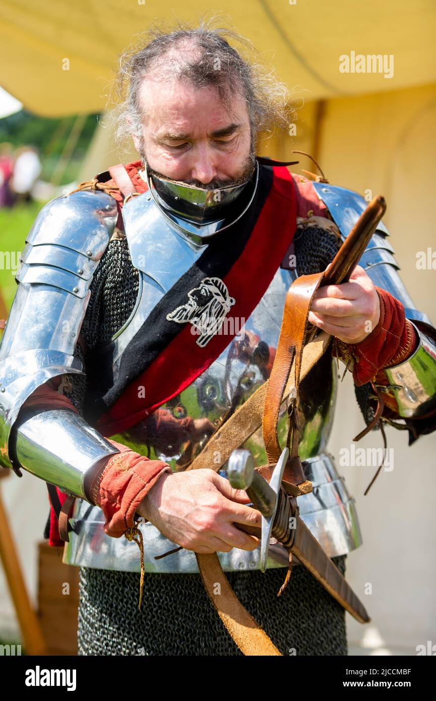 London, Großbritannien. 12. Juni 2022. James Simmonds, ein Re-enactor, bereitet sich auf den Kampf als Mann an den Armen der De Cobhams (Yorkisten) vor, während des Barnett Medieval Festival im Norden Londons. Es ist das einzige mittelalterliche Fest der Hauptstadt und widmet sich der Auseinandersetzung mit der Geschichte der Schlacht von Barnett und ihrer Bedeutung im Rahmen der Rosenkriege. In der Schlacht von Barnett führte Edward IV. Seine Yorkistische Armee am 14.. April 1471 zum Sieg gegen die Lancastrian-Truppen unter der Führung des Earl of Warwick. Kredit: Stephen Chung / Alamy Live Nachrichten Stockfoto