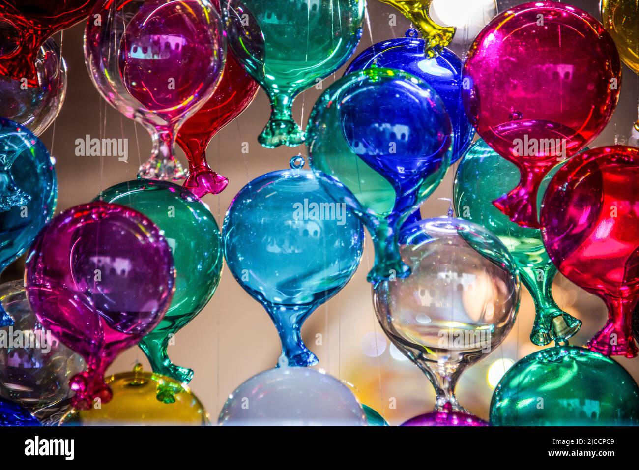 Viele Glasballons in verschiedenen Farben hängen von der Decke Stockfoto