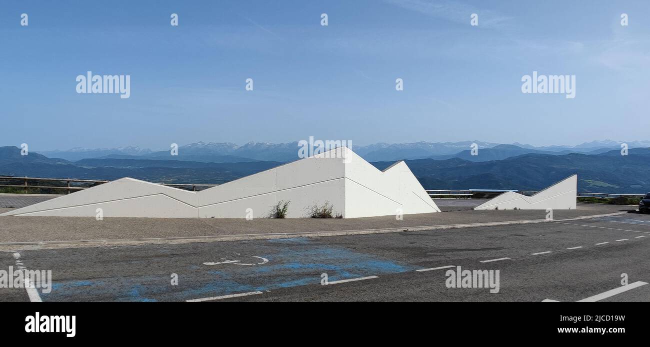 Panoramablick auf die pyrenäen mit verschneiten Spitzen moderner Ruhebereich hinter Betonwänden, der wie abstrakte Berge aussieht Stockfoto