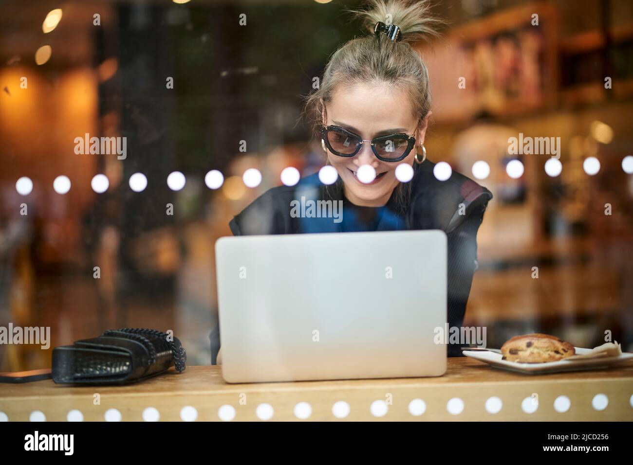 asiatische Frau, die mit einem Laptop im Café arbeitet Stockfoto