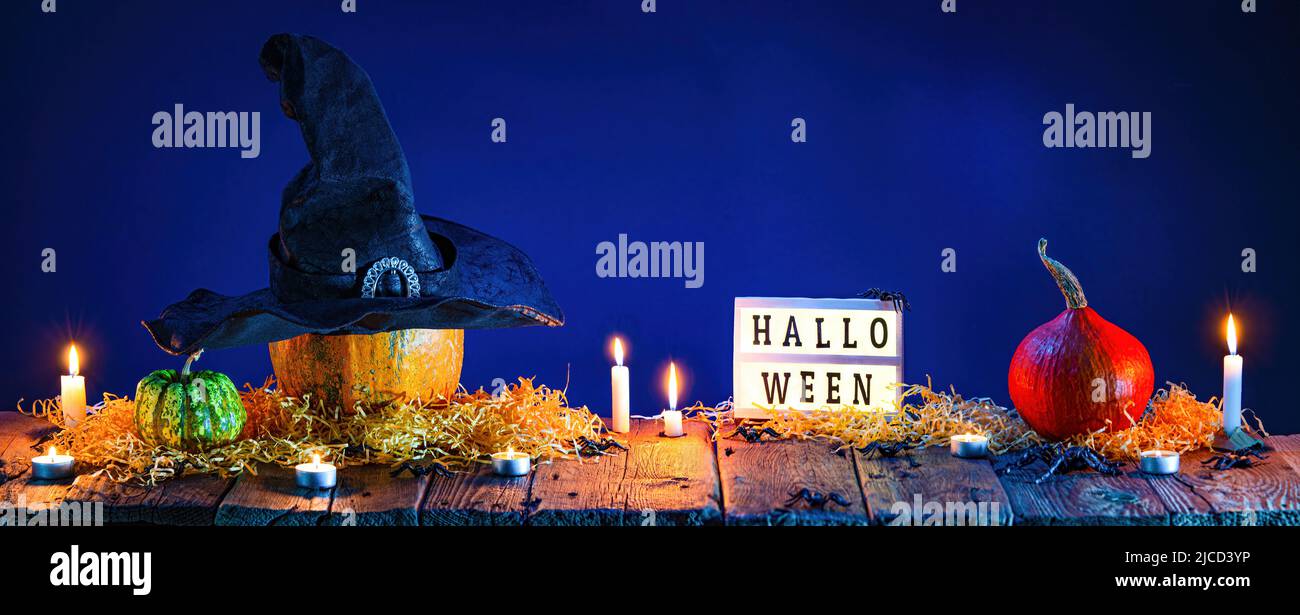 Halloween Hintergrund. Kürbisse und brennende Kerzen auf Holztisch Stockfoto